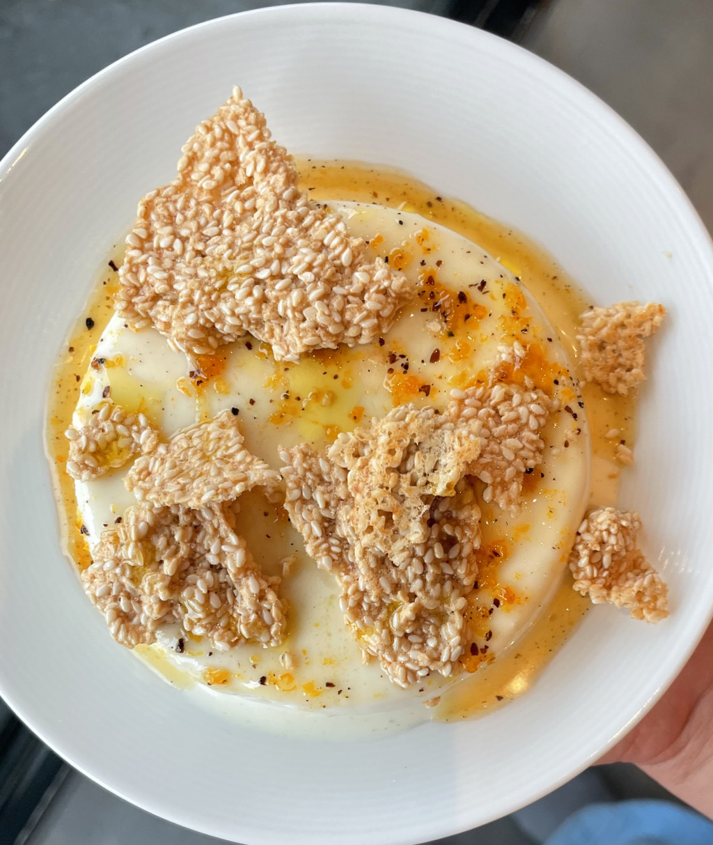A plate of bright golden crispy sesame crunch with bright sauce